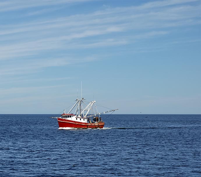 Image of a small fishing vessel out at sea, isolated