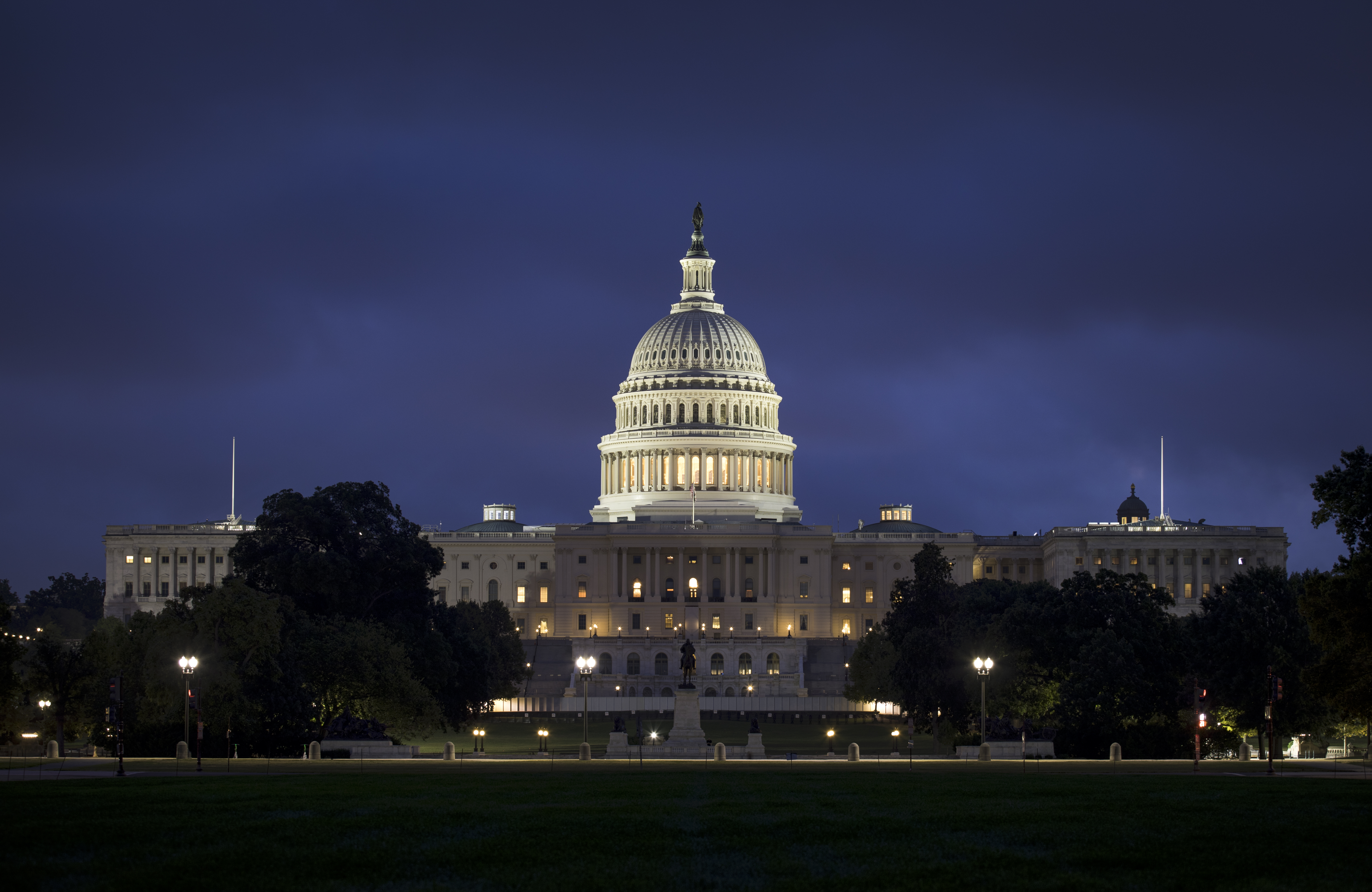 The U.S. Capitol Building illuminated at dusk under a dark blue sky in Washington, D.C.