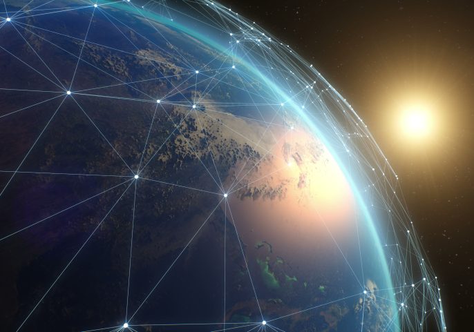 View of Earth from space with network lines connecting across continents and the sun glowing on the horizon.